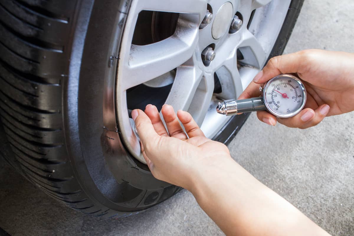 manually checking a car tire's pressure