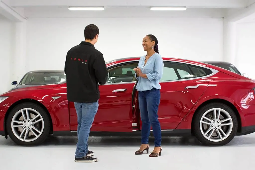 tesla employee assisting customer