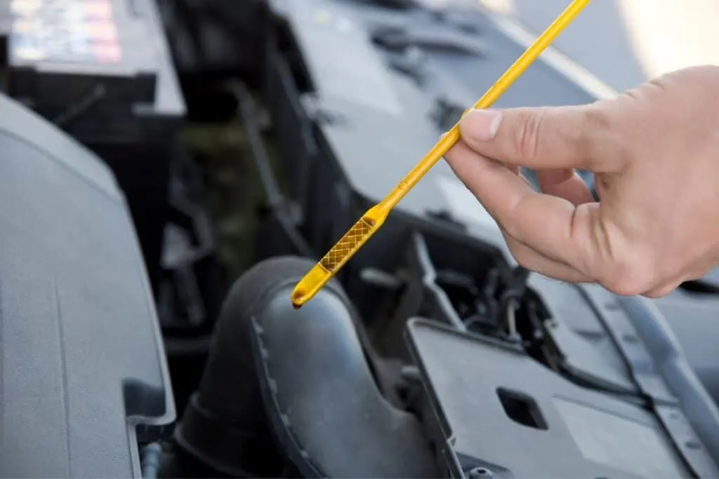 person checking engine oil dipstick