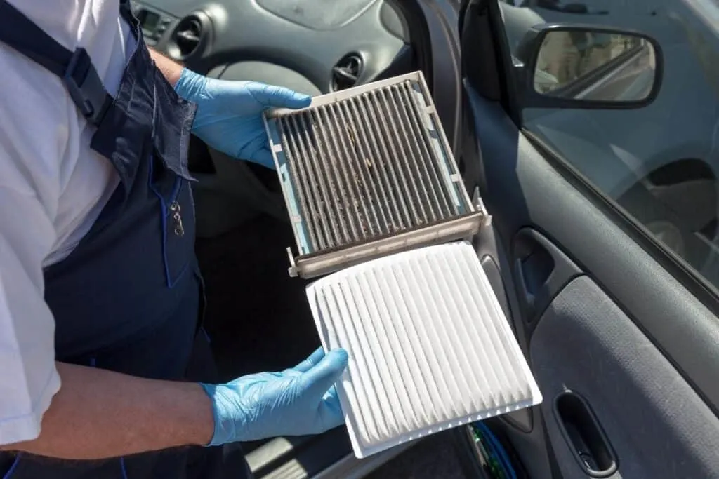 man holding dirty and clean air filters
