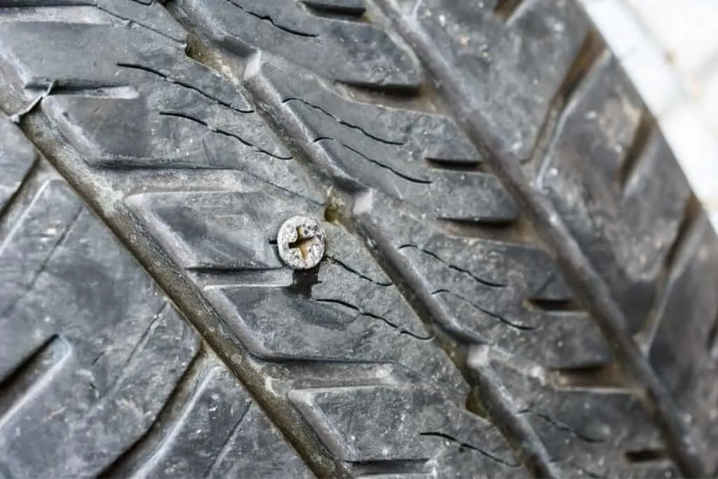 screw puncturing car tire