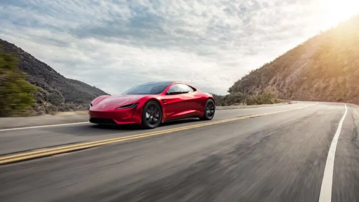 Red tesla running in the highway 