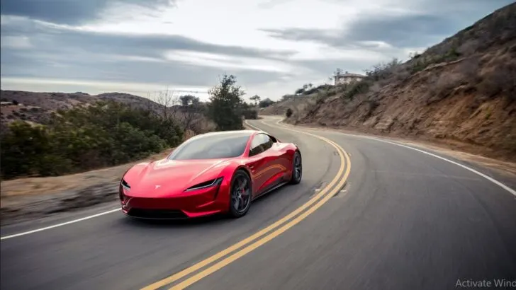 Red tesla running on a highway