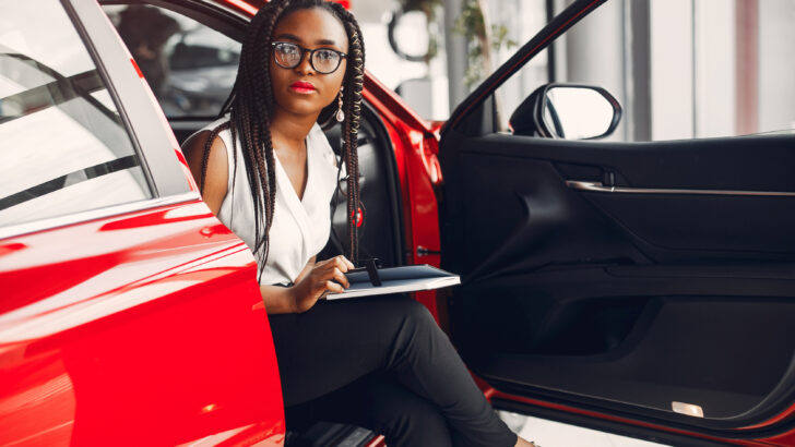 elegant black girl in a red car