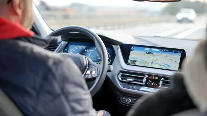 Man with glass driving the car and using GPS